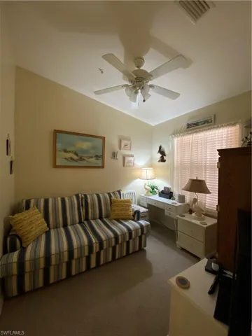 Carpeted bedroom featuring ceiling fan and lofted ceiling