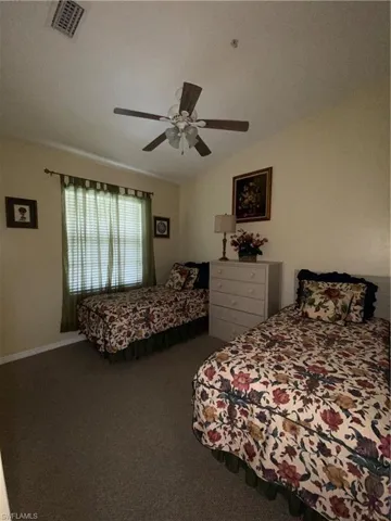 Bedroom with carpet floors, a ceiling fan, and lofted ceiling