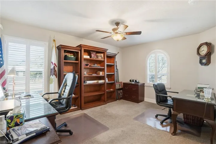 Office space with light colored carpet and a ceiling fan