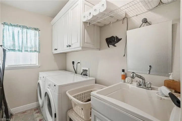 Laundry area featuring separate washer and dryer and cabinet space