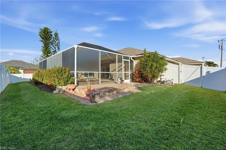 Rear view of house with a gate, a fenced backyard, a sunroom, a lanai, and a patio area