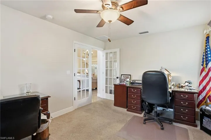 Office space with french doors, light colored carpet, and ceiling fan