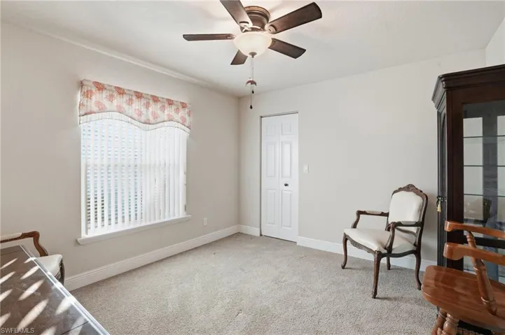 Bedroom with light colored carpet and a ceiling fan
