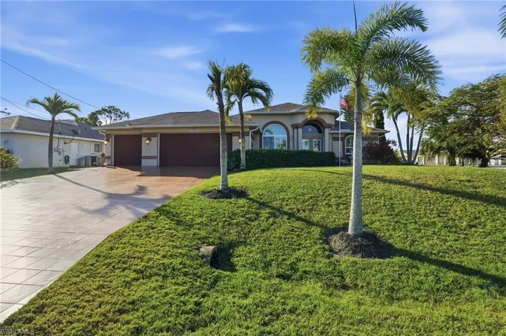 View of front facade with a front yard, a garage, decorative driveway, and stucco siding