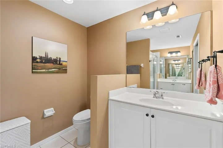 Bathroom featuring tile flooring, oversized vanity, and toilet
