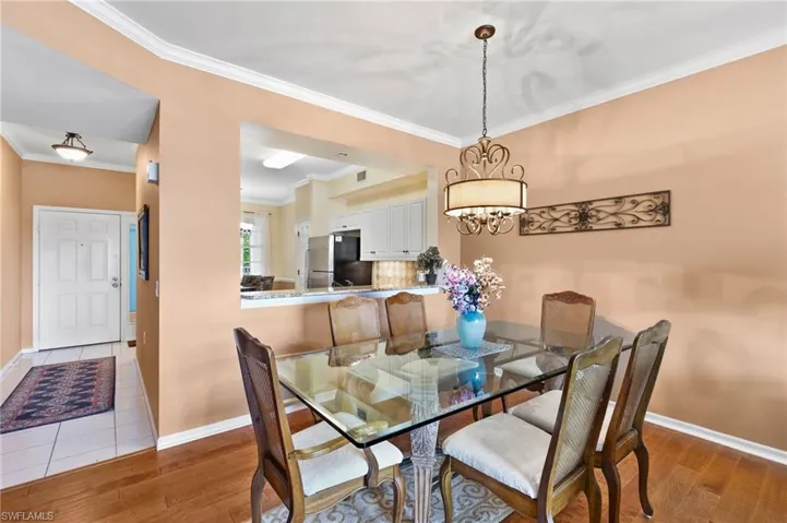 Dining room with hardwood flooring, a chandelier, and crown molding