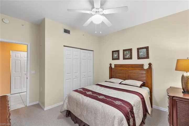Carpeted bedroom with a closet and ceiling fan