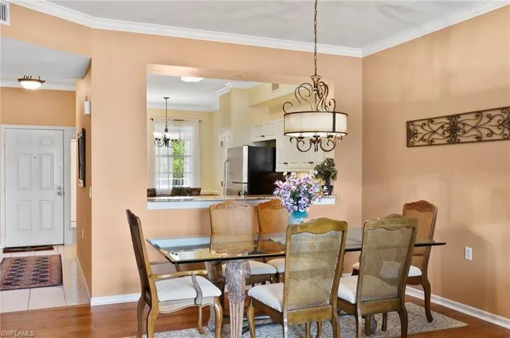 Tiled dining area with a notable chandelier and crown molding