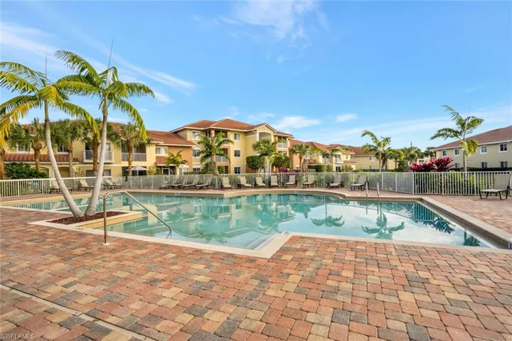 Community pool featuring fence, a residential view, and a patio area