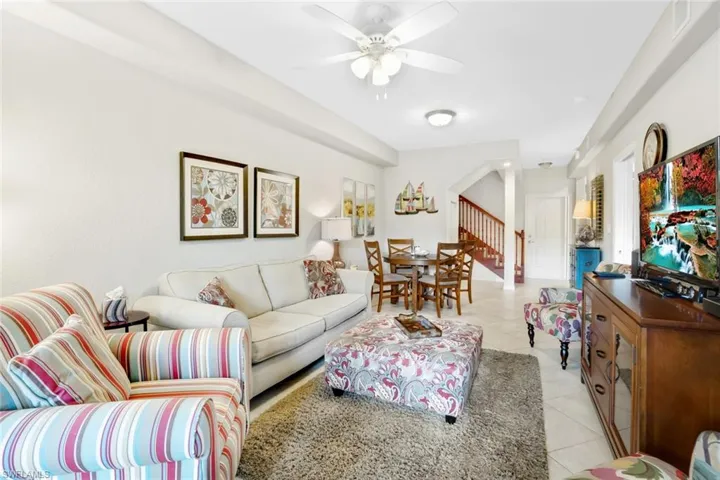 Living room featuring light tile patterned floors and ceiling fan