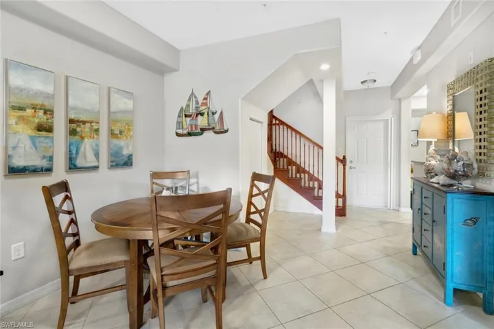 Dining space with stairs, light tile patterned floors, and baseboards