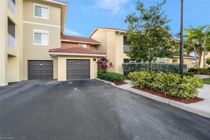 Multi unit property featuring stucco siding, a tiled roof, and driveway