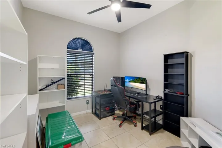 Office space with light tile patterned floors and a ceiling fan