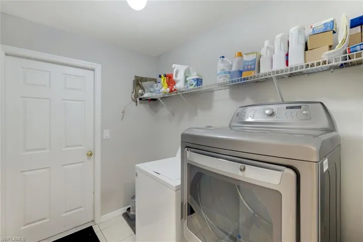 Laundry room featuring light tile patterned floors and separate washer and dryer