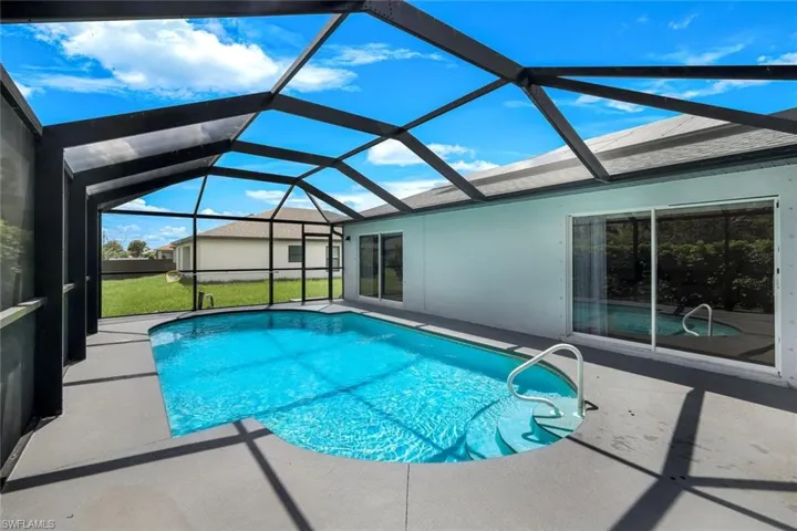 Outdoor pool featuring a sunroom, a patio, a lanai, and a lawn