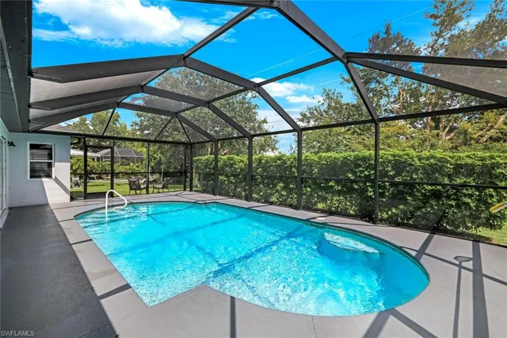 Swimming pool featuring a sunroom, a lanai, and a patio area