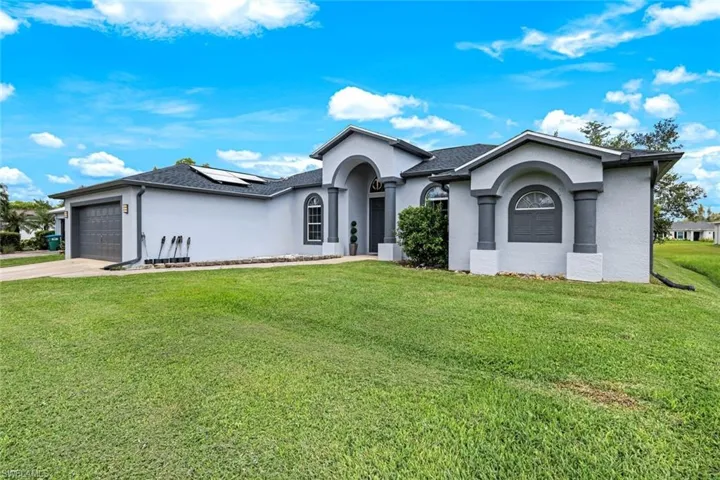 Ranch-style home featuring stucco siding, an attached garage, concrete driveway, and a front lawn