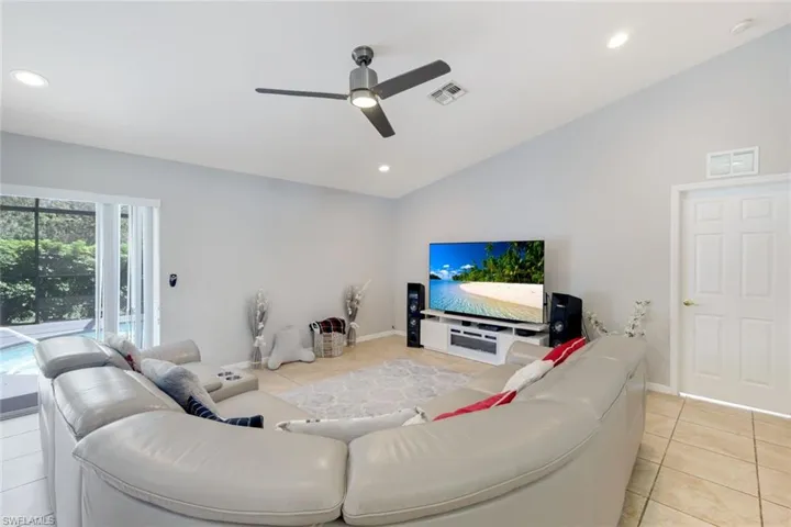 Living area with light tile patterned flooring, lofted ceiling, recessed lighting, and a ceiling fan