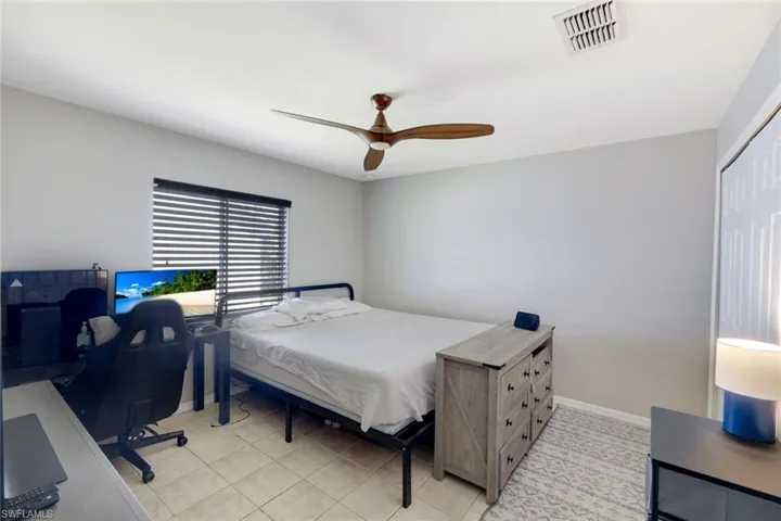 Bedroom with ceiling fan and light tile patterned floors