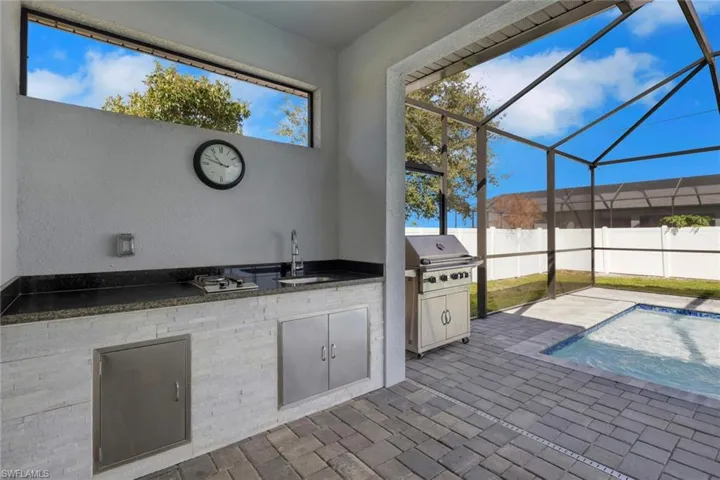 View of patio / terrace with exterior kitchen, a lanai, and a sunroom