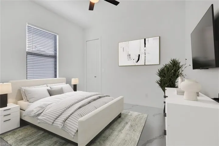 Bedroom featuring a ceiling fan and marble finish flooring