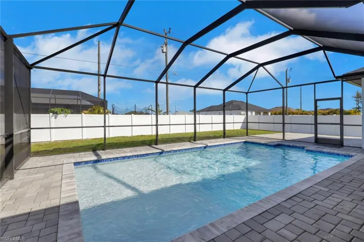 View of swimming pool featuring a sunroom, a fenced backyard, and glass enclosure