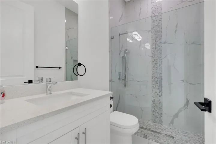 Full bathroom featuring vanity and a marble finish shower