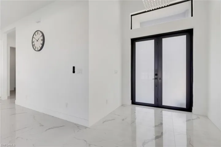 Foyer with french doors, light marble finish flooring, and plenty of natural light