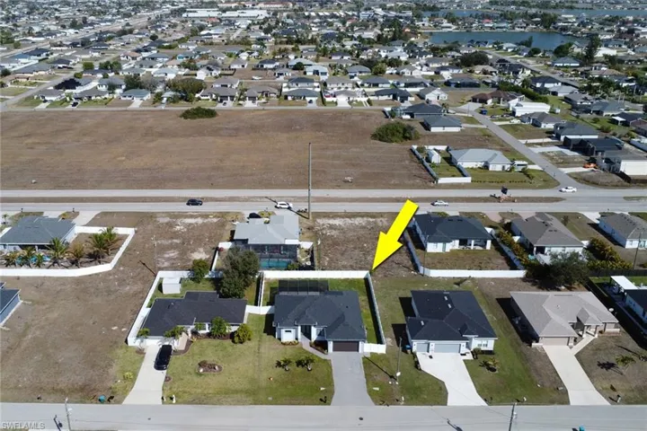 Aerial view of property and surrounding area featuring nearby suburban area
