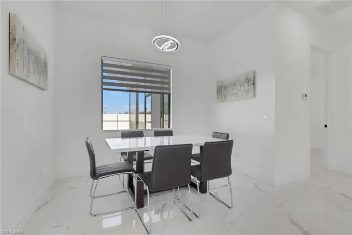 Dining space with baseboards and light marble finish floors