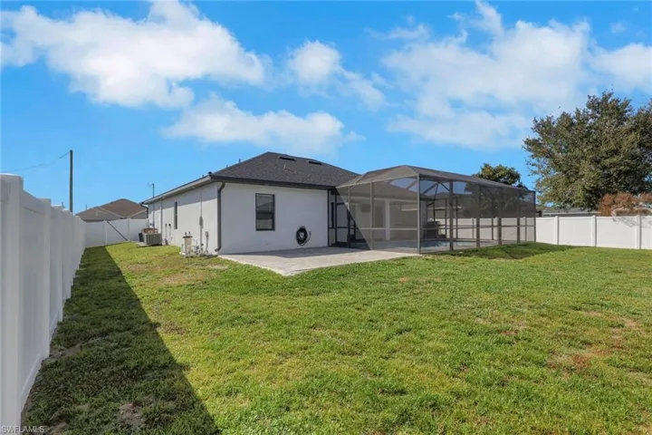 Rear view of property featuring a fenced backyard, a patio, glass enclosure, a sunroom, and stucco siding