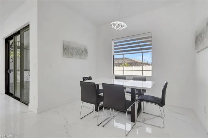 Dining space with baseboards and light marble finish floors