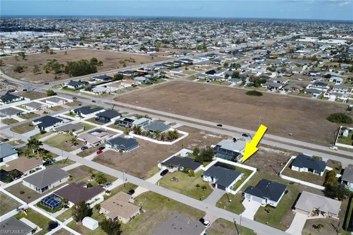Aerial view of property and surrounding area with nearby suburban area
