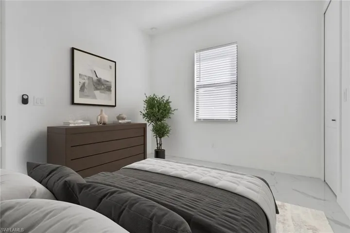 Bedroom featuring marble finish flooring and a closet