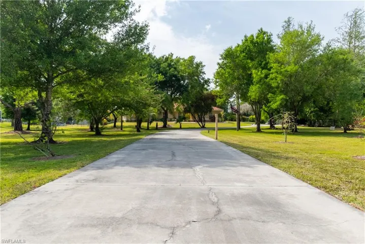 Surrounding community with a lawn and concrete driveway