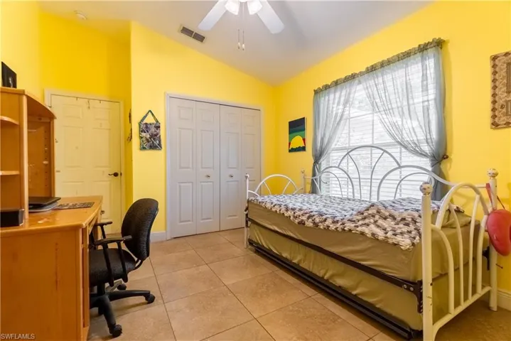 Bedroom featuring light tile patterned flooring, a closet, a ceiling fan, lofted ceiling, and visible vents