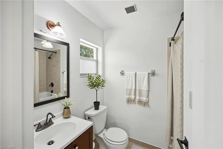 Full bathroom with vanity, toilet, and walk-in shower.