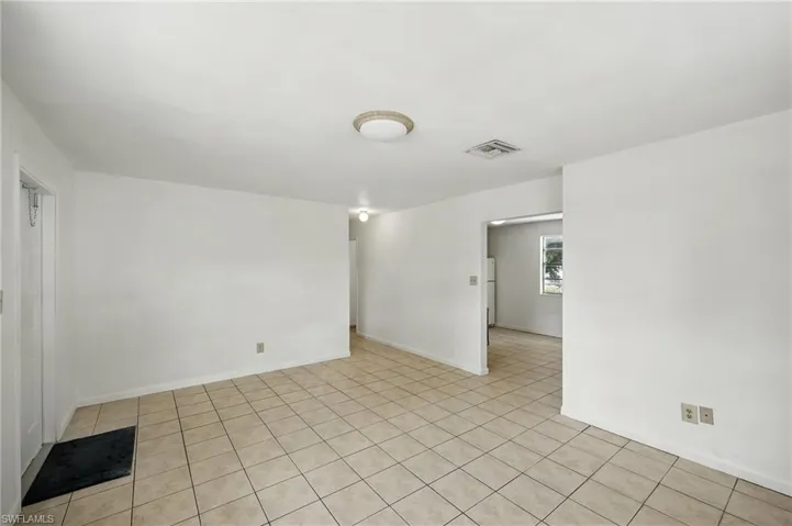 Empty room with baseboards and light tile patterned floors