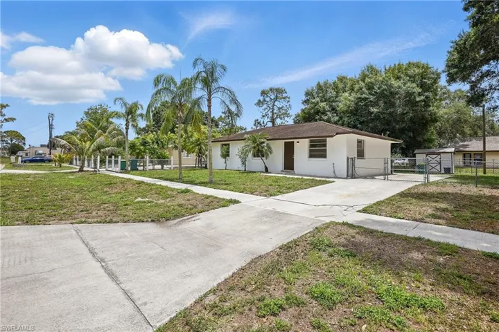 Single story home featuring a gate, driveway, and stucco siding