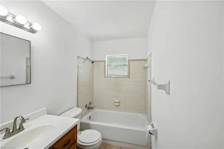 Full bath with toilet, vanity, bathing tub / shower combination, and tile patterned floors