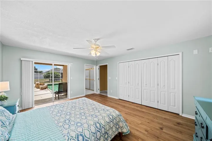 Bedroom featuring access to outside, baseboards, wood finished floors, and ceiling fan