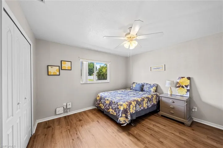 Bedroom with a closet, wood finished floors, baseboards, and a ceiling fan