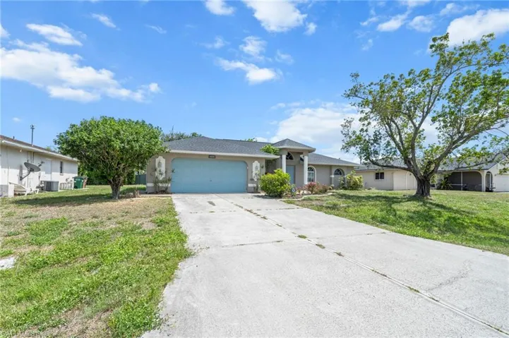 Ranch-style house with an attached garage, concrete driveway, a front yard, and stucco siding