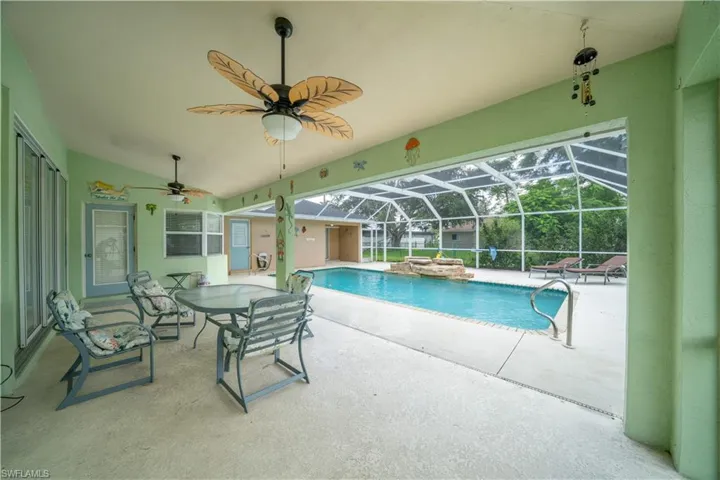 Outdoor pool featuring a patio, a ceiling fan, and a lanai