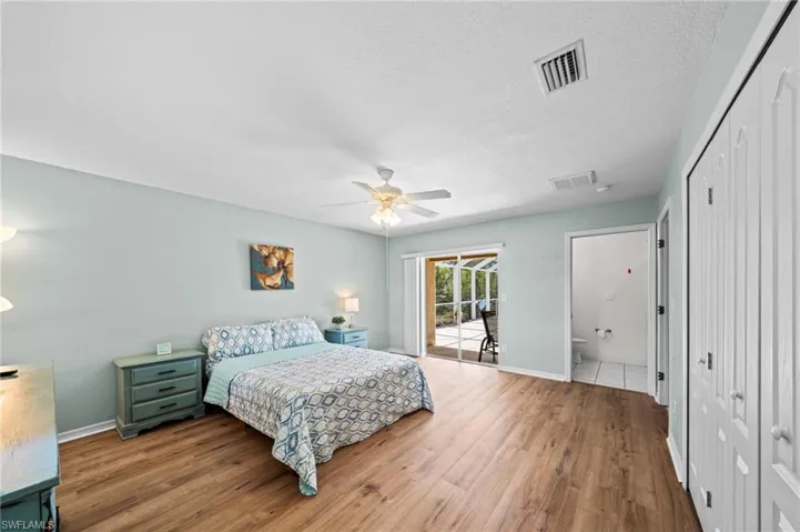 Bedroom featuring access to outside, wood finished floors, baseboards, and ceiling fan