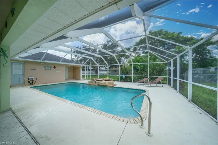 Outdoor pool with a patio area and glass enclosure