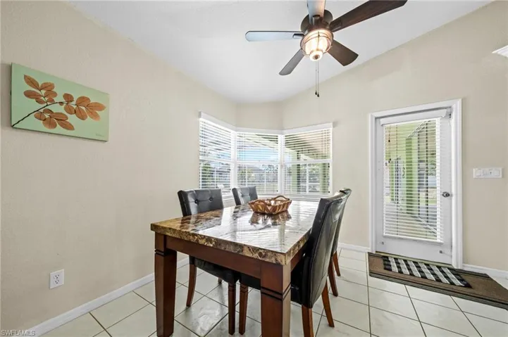 Dining room featuring ceiling fan, baseboards, and light tile patterned flooring