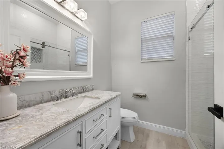 Bathroom featuring a white vanity with a marble countertop