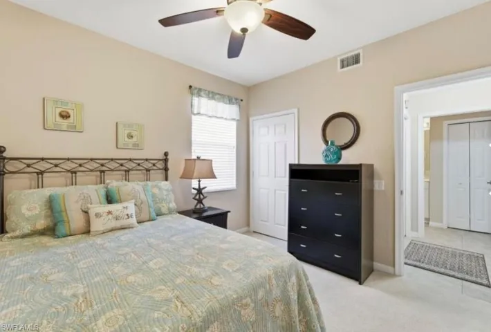 Bedroom featuring light carpet, a ceiling fan, and a closet