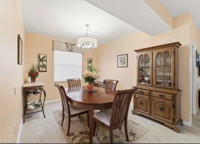 Dining room featuring light tile patterned floors and baseboards